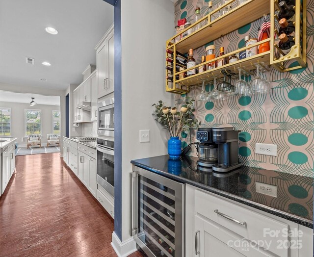 bar with visible vents, wine cooler, stainless steel appliances, recessed lighting, and dark wood-type flooring