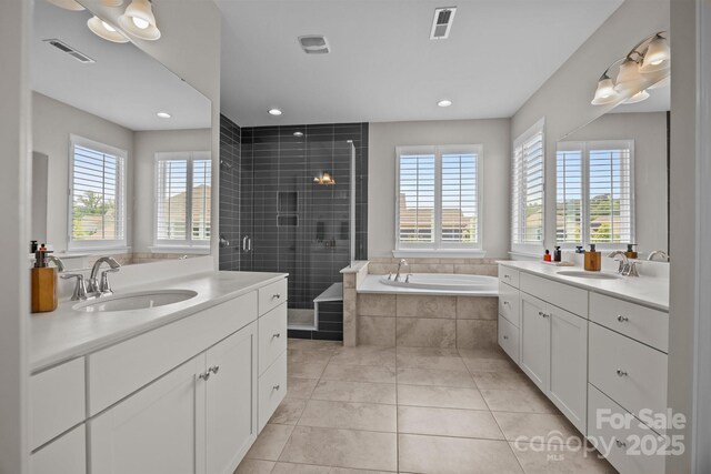 bathroom featuring a sink, a shower stall, a garden tub, and visible vents
