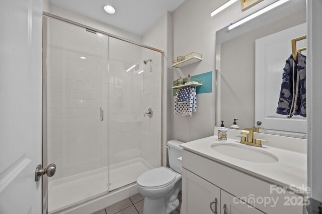 bathroom featuring toilet, tile patterned floors, a shower stall, and vanity