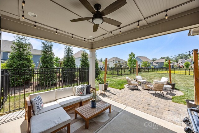 view of patio / terrace with an outdoor living space, a fenced backyard, ceiling fan, and a residential view