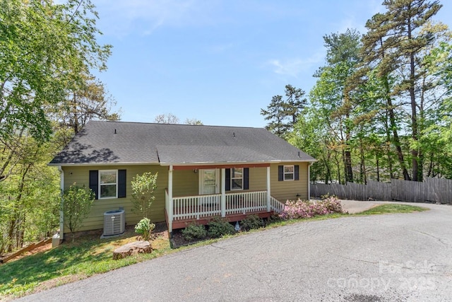 view of front of home with covered porch, fence, and central air condition unit
