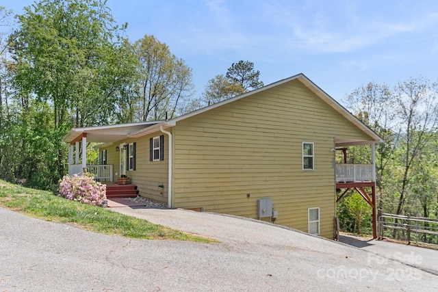 view of property exterior featuring a porch and driveway