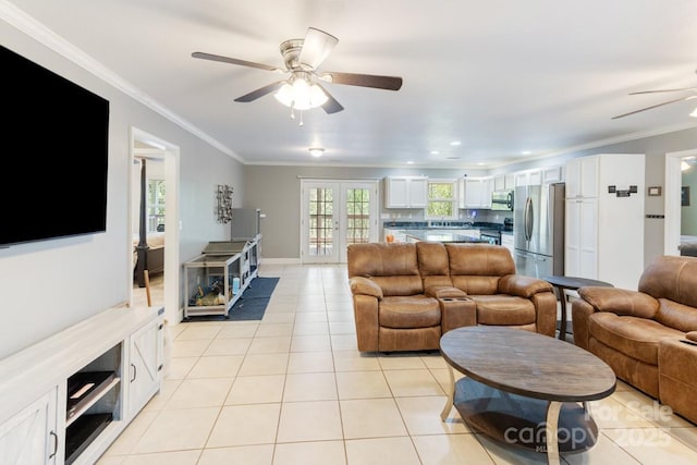 living area featuring crown molding, light tile patterned flooring, and ceiling fan