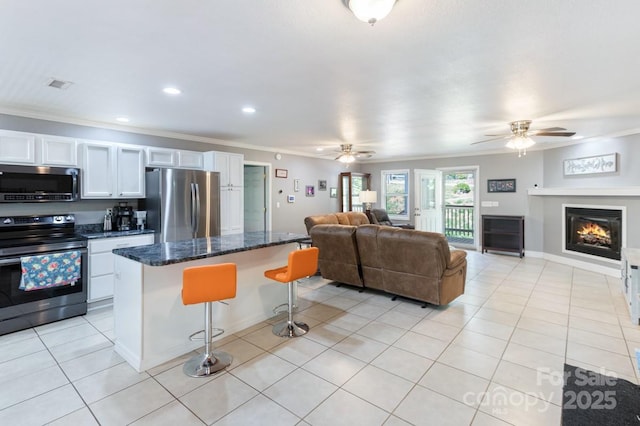 kitchen with ornamental molding, stainless steel appliances, ceiling fan, and open floor plan