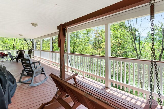 wooden deck featuring outdoor dining area and a grill