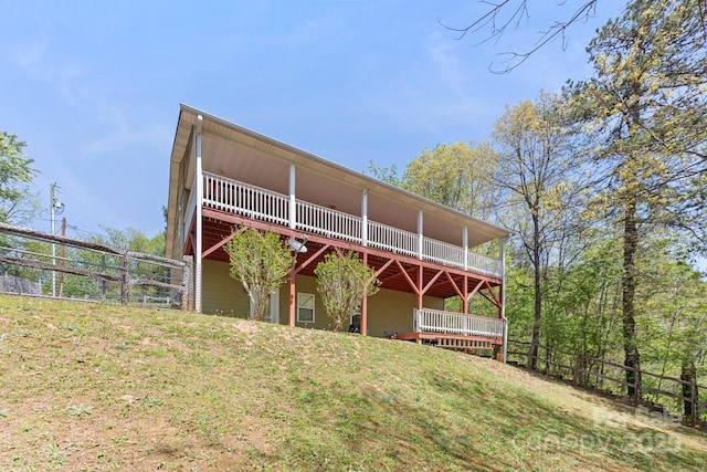 back of property with a deck and fence