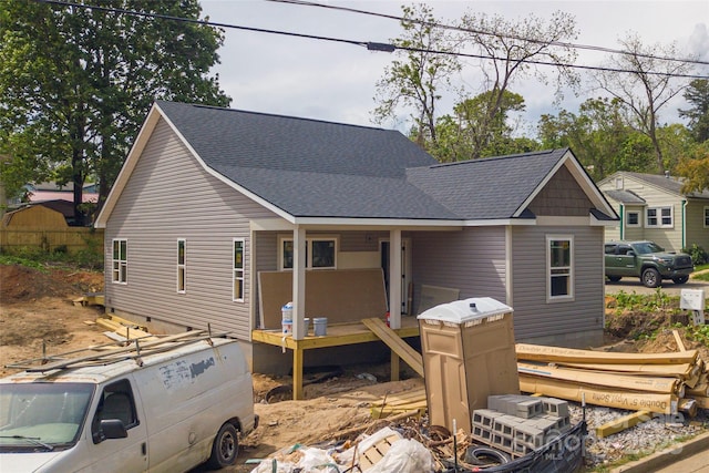 rear view of property featuring a shingled roof and crawl space