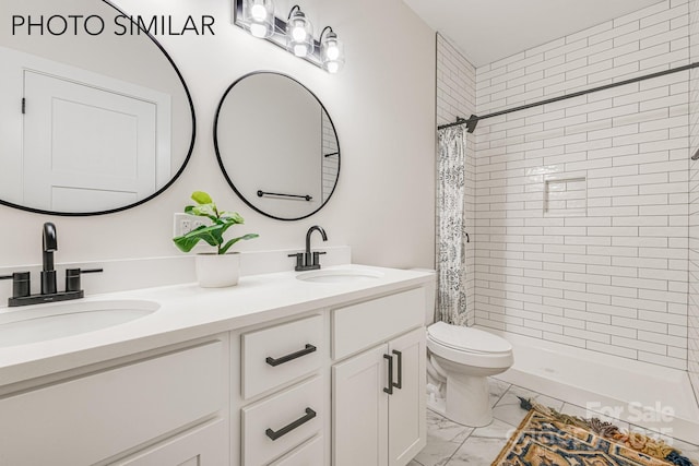bathroom featuring double vanity, marble finish floor, a stall shower, and a sink
