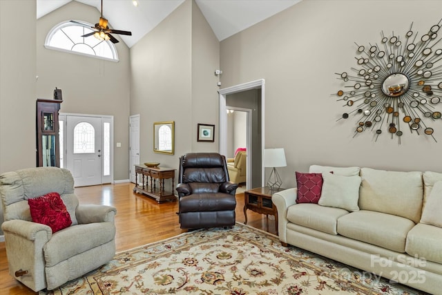 living room featuring high vaulted ceiling, ceiling fan, and wood finished floors