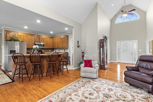 living room with recessed lighting, high vaulted ceiling, ceiling fan, and light wood finished floors