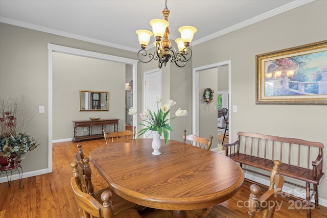 dining area featuring baseboards, an inviting chandelier, ornamental molding, and light wood-style floors