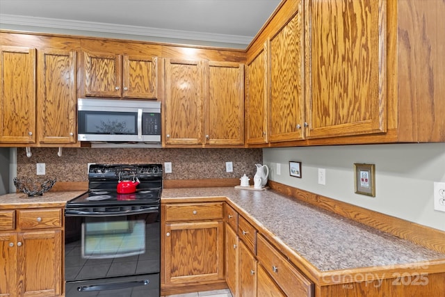 kitchen featuring crown molding, brown cabinets, tile patterned flooring, stainless steel microwave, and black / electric stove