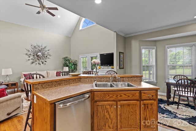 kitchen with a breakfast bar area, a ceiling fan, stainless steel dishwasher, a sink, and open floor plan
