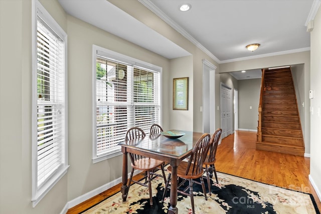 dining room featuring baseboards, ornamental molding, a healthy amount of sunlight, and stairway