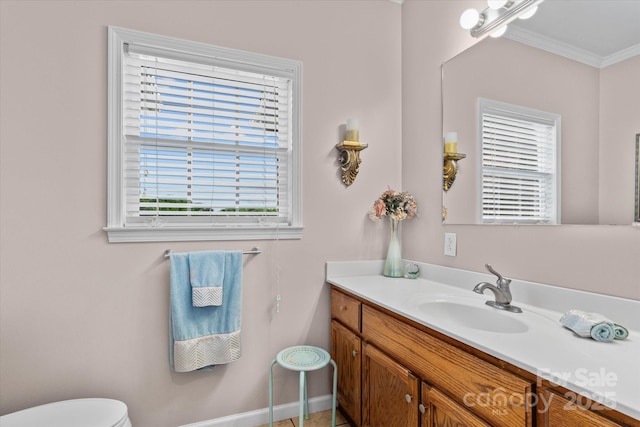 bathroom featuring crown molding, toilet, baseboards, and vanity