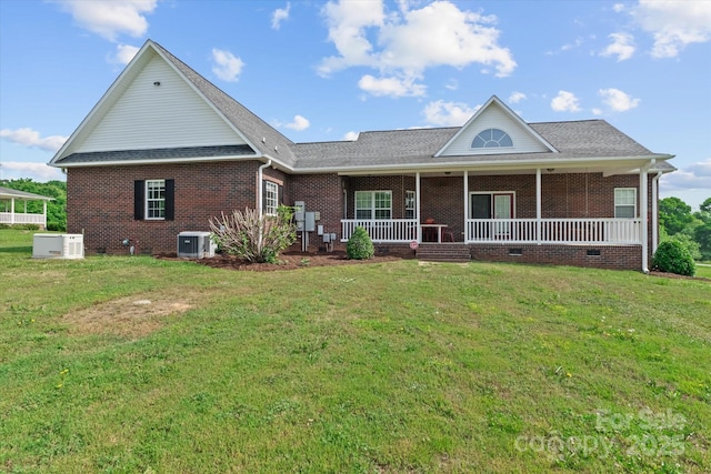 rear view of house with a yard, brick siding, central AC unit, and covered porch