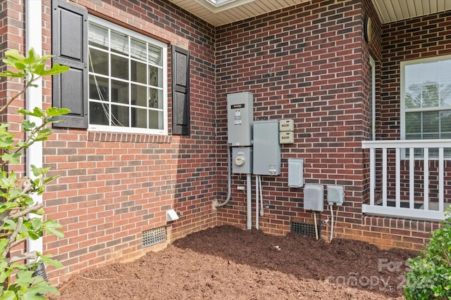 exterior details with brick siding, crawl space, and electric meter