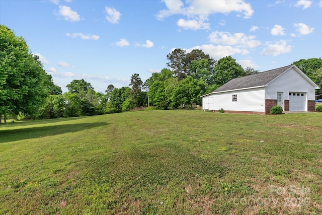 view of yard featuring a garage and an outbuilding