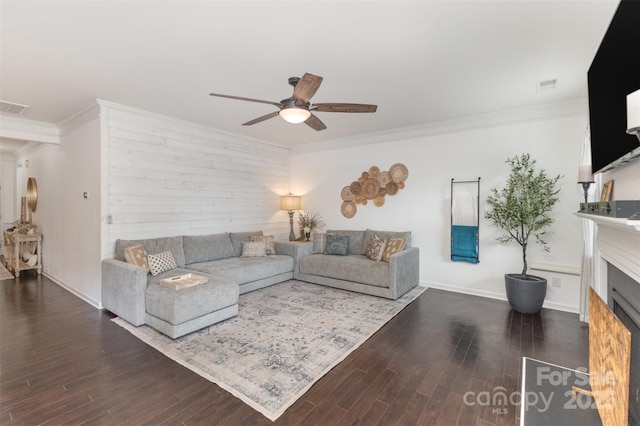 living room with ceiling fan, ornamental molding, wood finished floors, and a fireplace