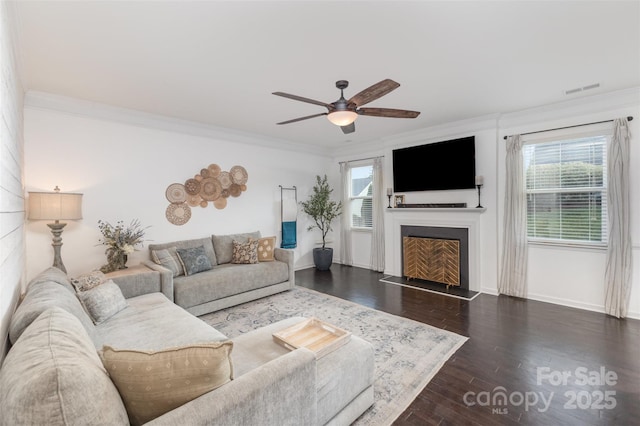living room featuring plenty of natural light, ornamental molding, and a ceiling fan