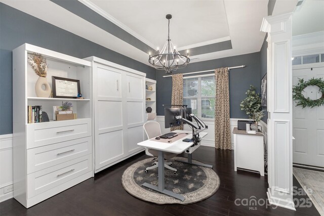 home office featuring crown molding, a notable chandelier, dark wood finished floors, a wainscoted wall, and decorative columns