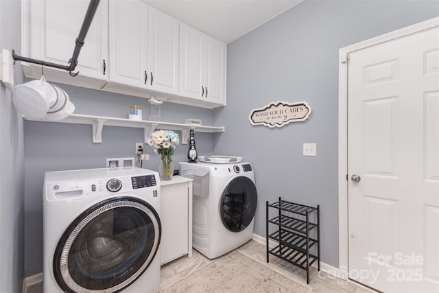 washroom featuring washer and dryer, baseboards, and cabinet space