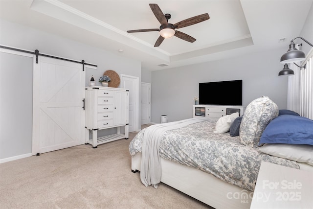bedroom with ornamental molding, ceiling fan, a barn door, a raised ceiling, and carpet flooring