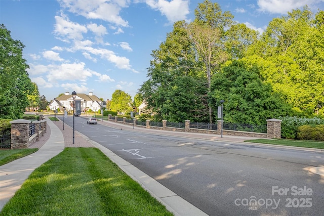 view of street featuring sidewalks, curbs, and street lighting