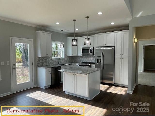 kitchen with crown molding, decorative backsplash, a kitchen island, a sink, and stainless steel appliances