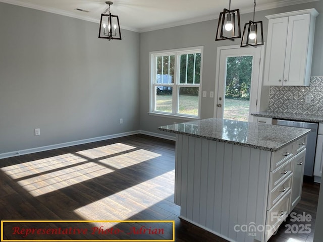kitchen with a kitchen island, backsplash, white cabinetry, and visible vents