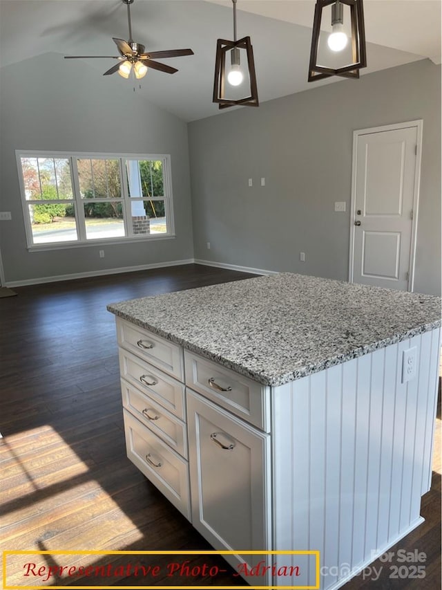 kitchen featuring light stone countertops, baseboards, a ceiling fan, dark wood finished floors, and vaulted ceiling