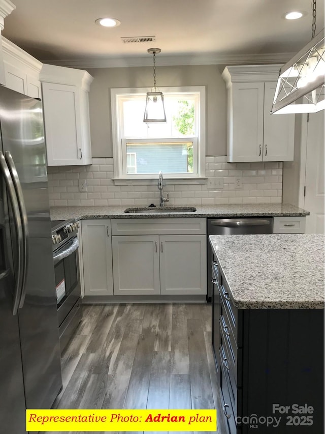kitchen featuring visible vents, a sink, appliances with stainless steel finishes, and white cabinets