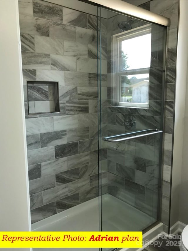 full bathroom featuring a stall shower and toilet