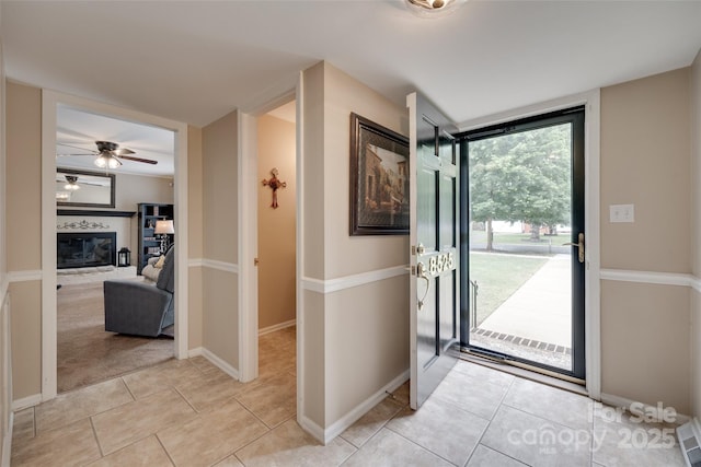 8525 Castlekeep Rd Unit 26, Charlotte, NC 28226 - entryway with a ceiling fan, light tile patterned floors, a glass covered fireplace, and baseboards