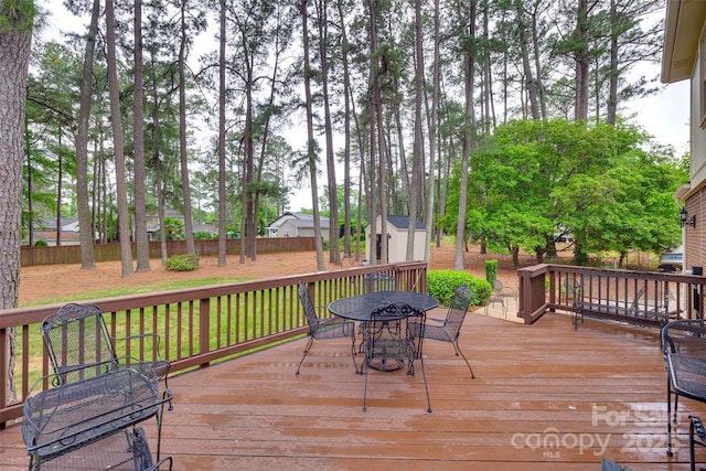 8525 Castlekeep Rd Unit 26, Charlotte, NC 28226 - wooden deck with outdoor dining area, a storage unit, and an outbuilding