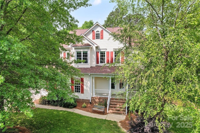 view of front of property with covered porch and roof with shingles