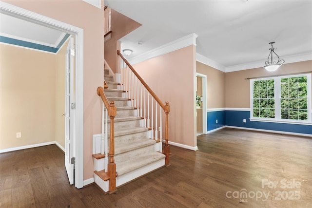 stairway featuring baseboards, ornamental molding, and wood finished floors