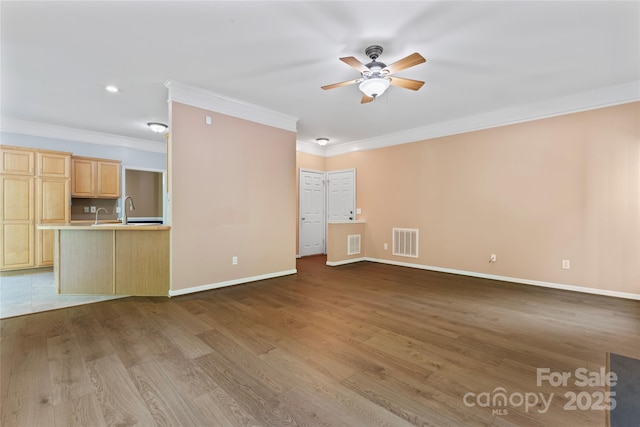 unfurnished living room with visible vents, ornamental molding, baseboards, and a ceiling fan