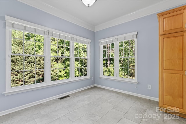 unfurnished room with visible vents, ornamental molding, baseboards, and light tile patterned floors