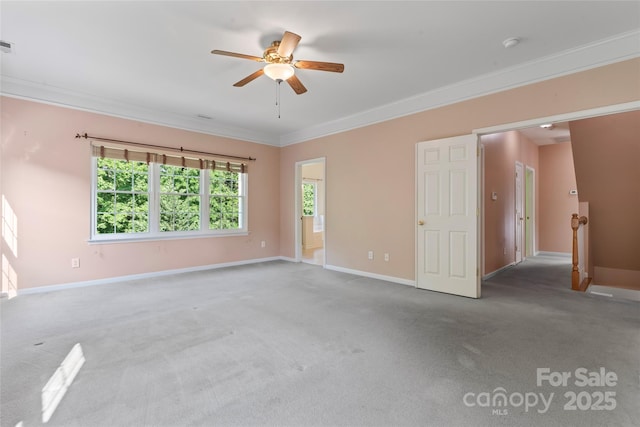 spare room featuring ceiling fan, ornamental molding, baseboards, and carpet