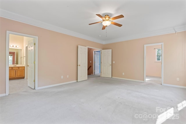 unfurnished bedroom featuring crown molding, baseboards, light carpet, and connected bathroom