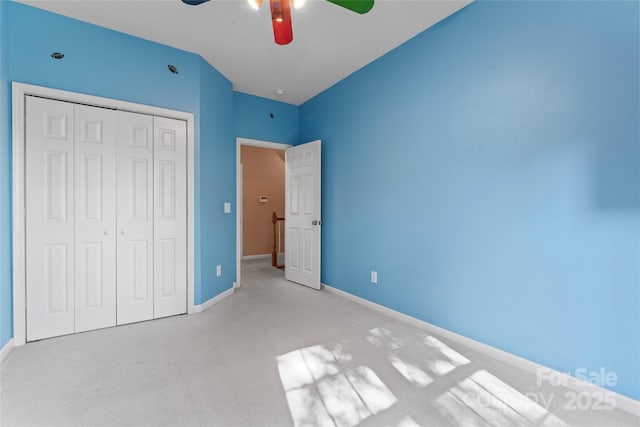 unfurnished bedroom with carpet floors, a ceiling fan, baseboards, and a closet