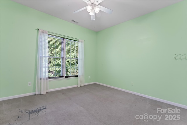 unfurnished room featuring carpet floors, a ceiling fan, baseboards, and visible vents