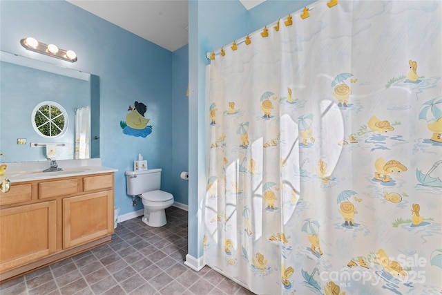 bathroom with toilet, baseboards, and vanity