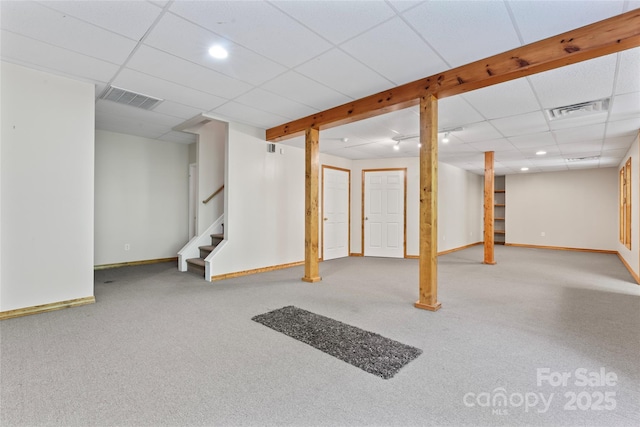finished basement with stairway, baseboards, and visible vents
