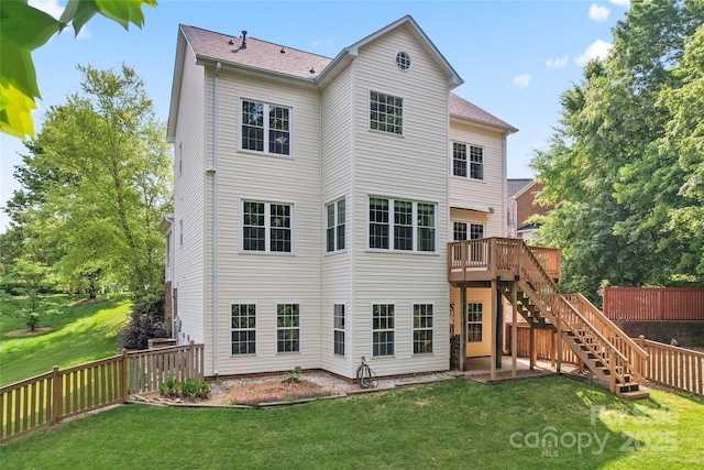 back of property with stairway, a yard, fence, and a wooden deck