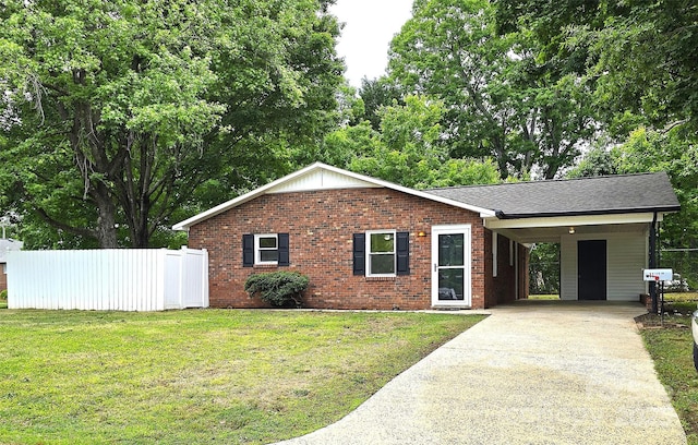 ranch-style house featuring fence, a front yard, driveway, and brick siding