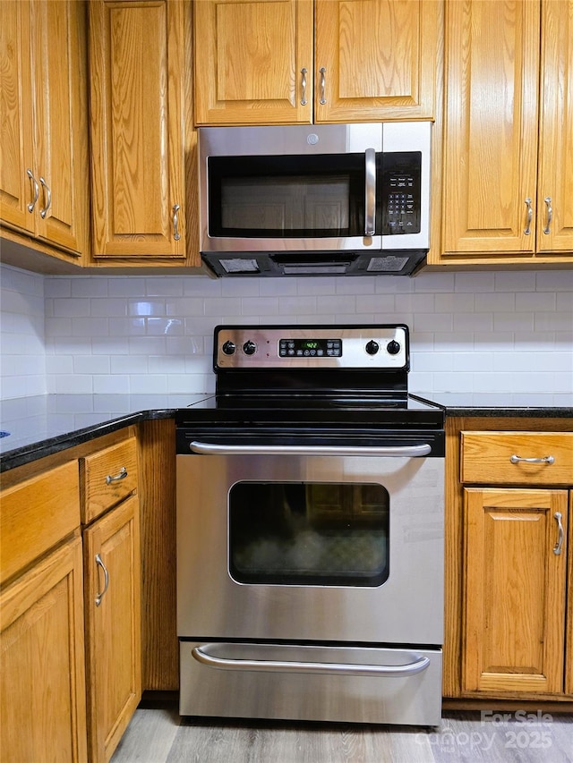kitchen featuring stainless steel appliances, brown cabinetry, and tasteful backsplash