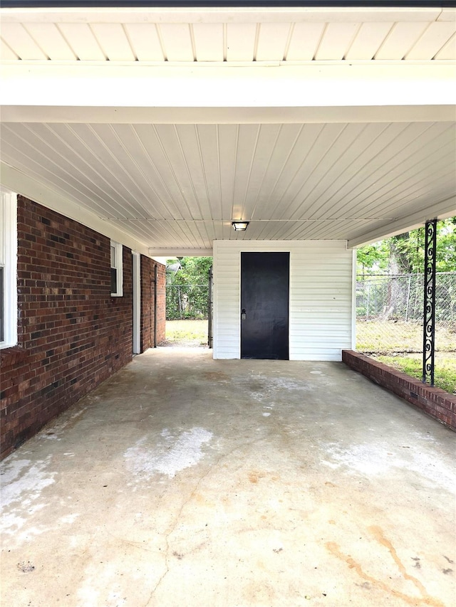 view of patio / terrace with fence and a carport