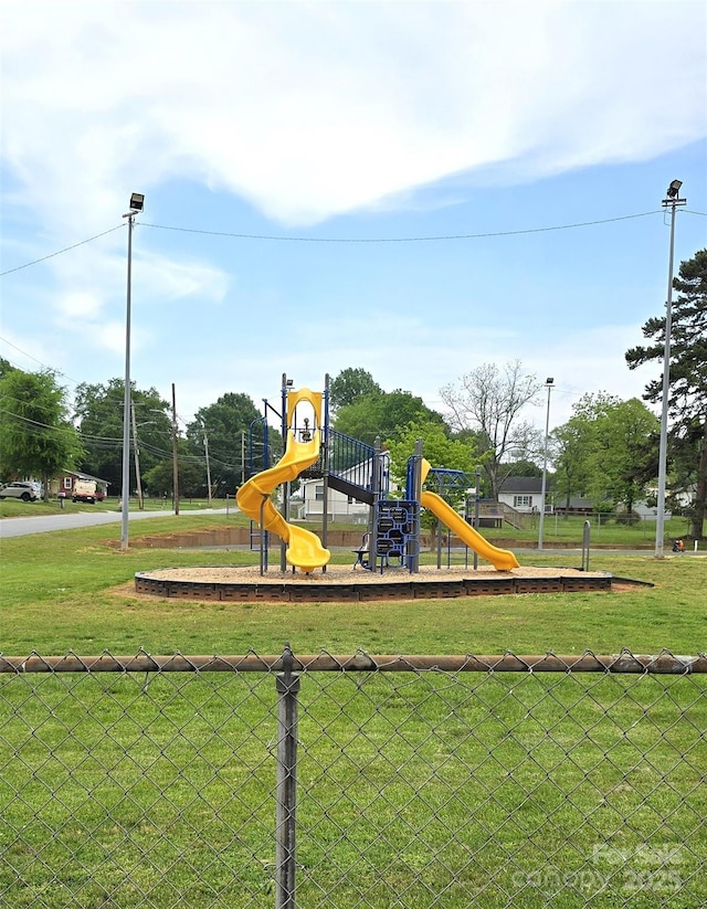 community playground featuring a lawn and fence
